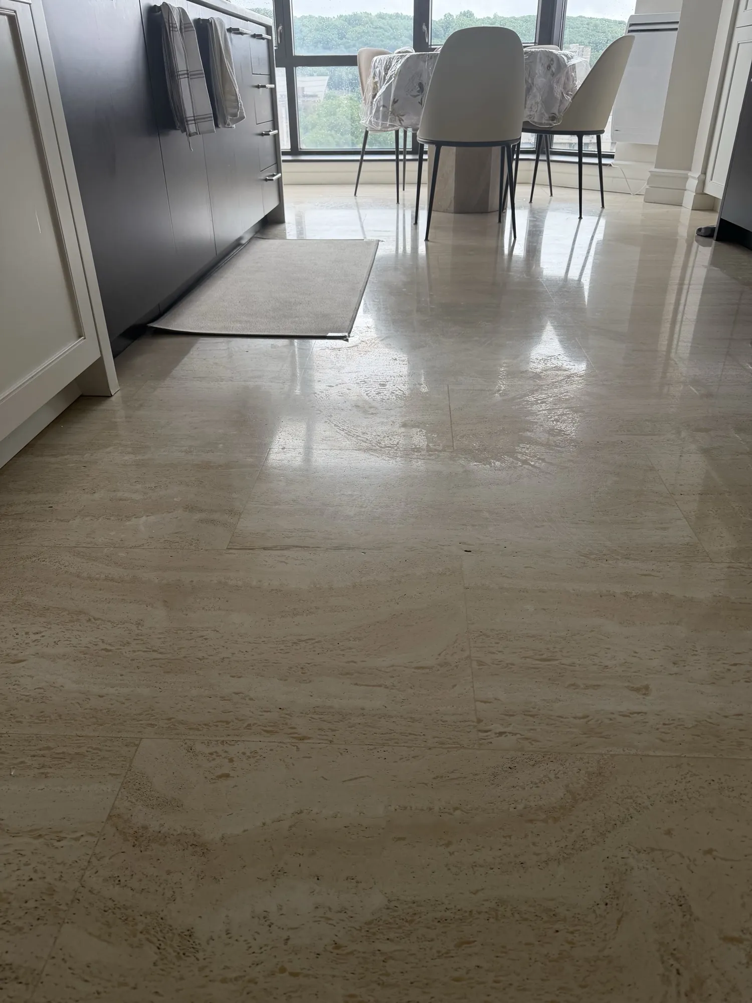 Travertine dining-area floor after high-gloss restoration in Outremont