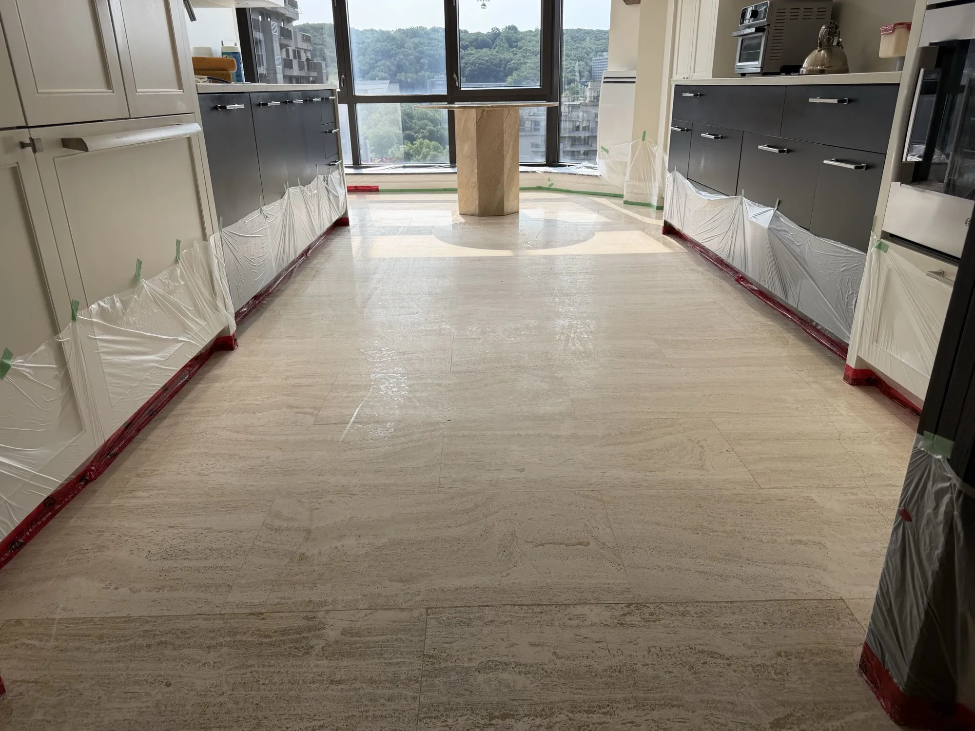 Diamond sanding in progress on a travertine kitchen floor in Outremont